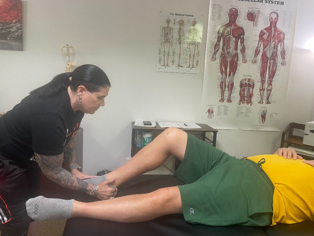 Luanne performing Muscle Activation Techniques on a client's lower leg